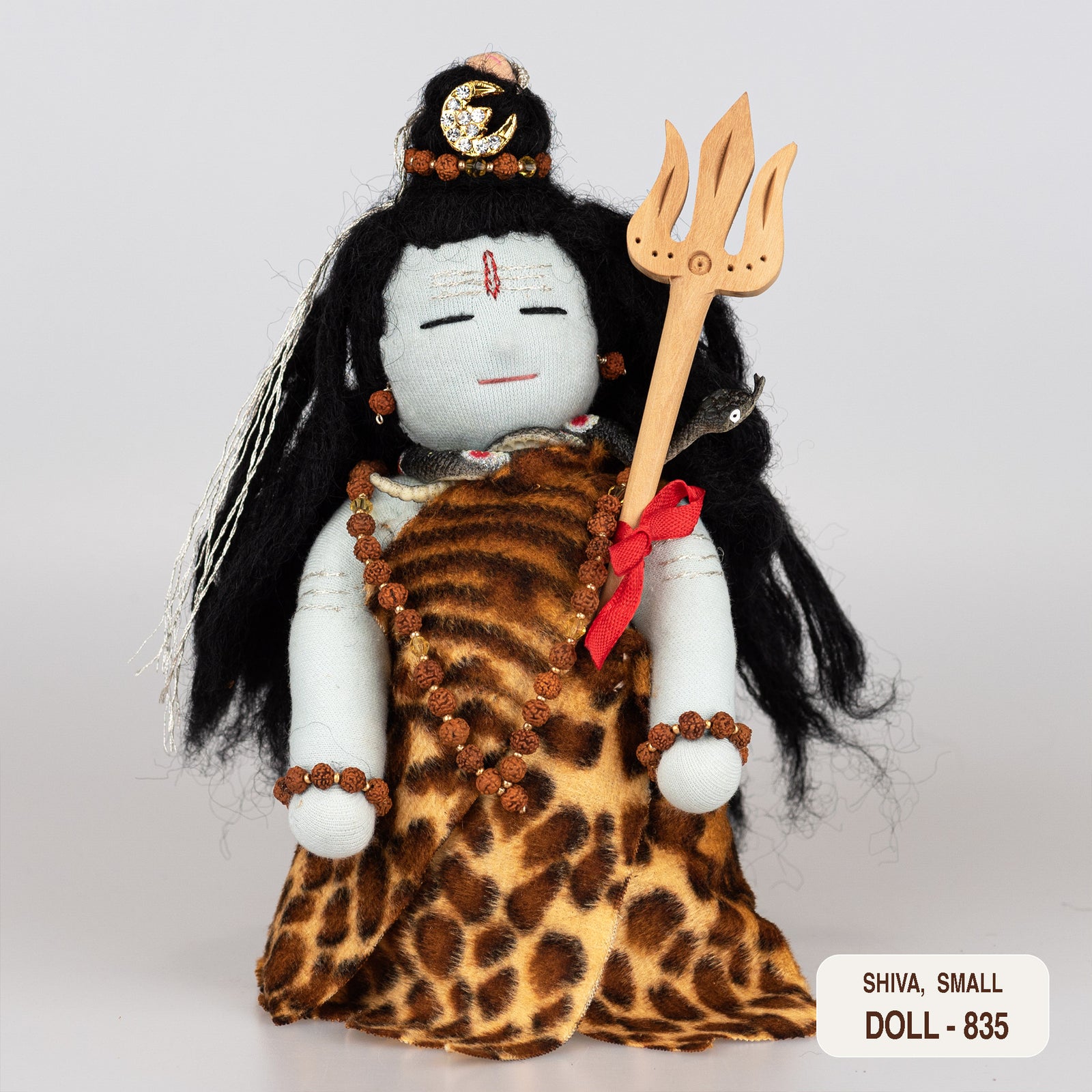 A handcrafted doll of the Hindu god Shiva, dressed in a tiger skin garment, holding a trident, with a cobra around the neck and matted hair.